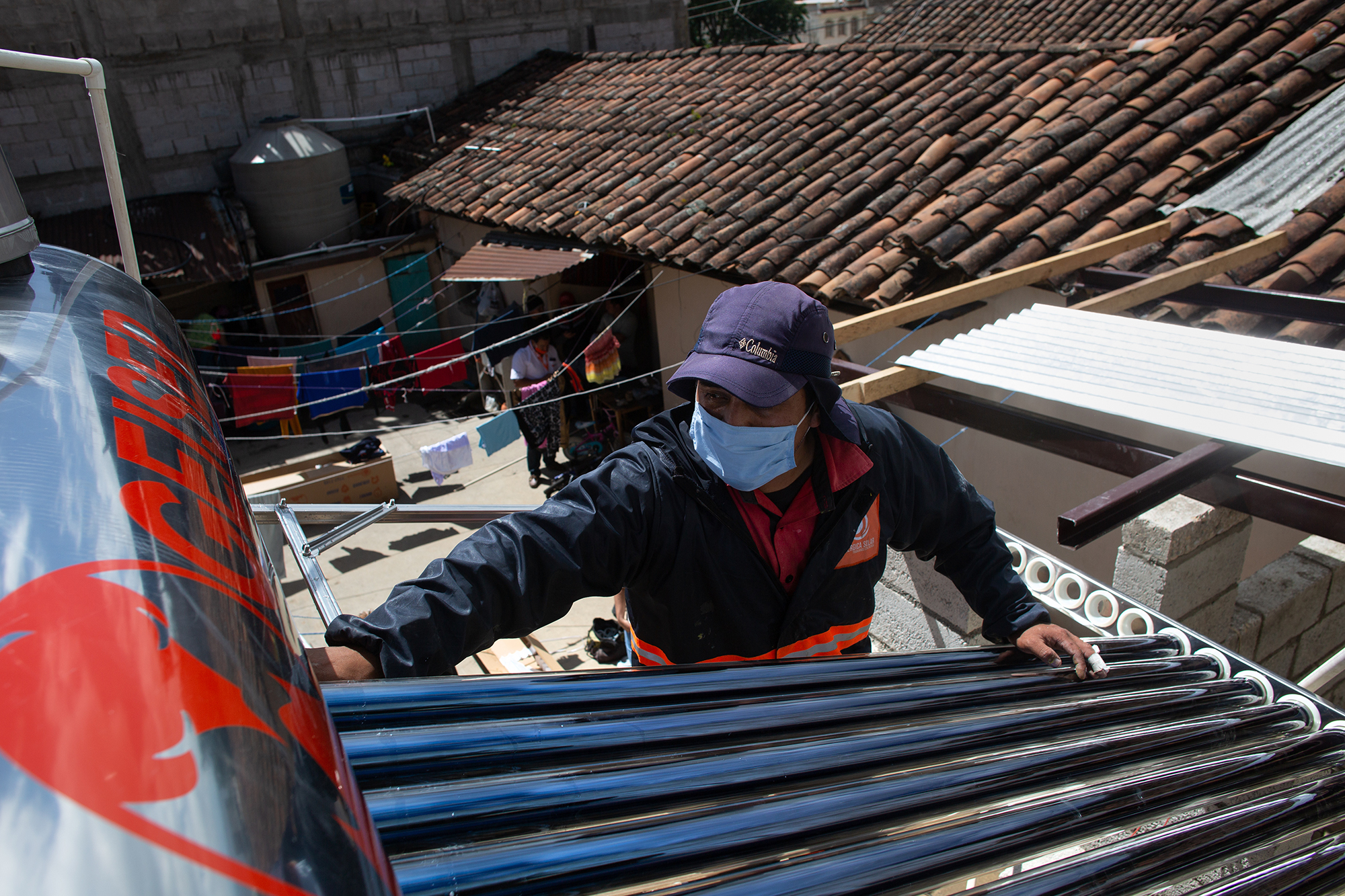 2.1.40 Man On Roof With Solar Panel Alterna Enérgice Solar Copyright James Rodríguez Panos